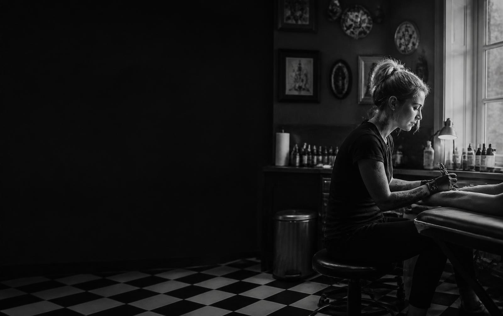 Tatovør i arbeid i et mørkt vintage-inspirert studio